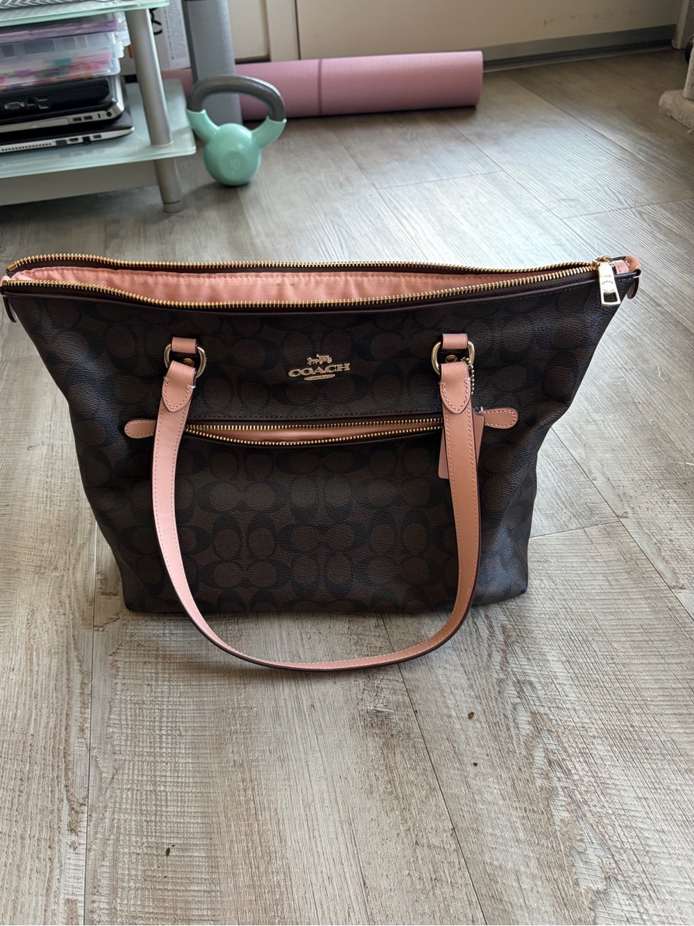 Coach Gallery Tote features signature dark brown canvas with peachy pink